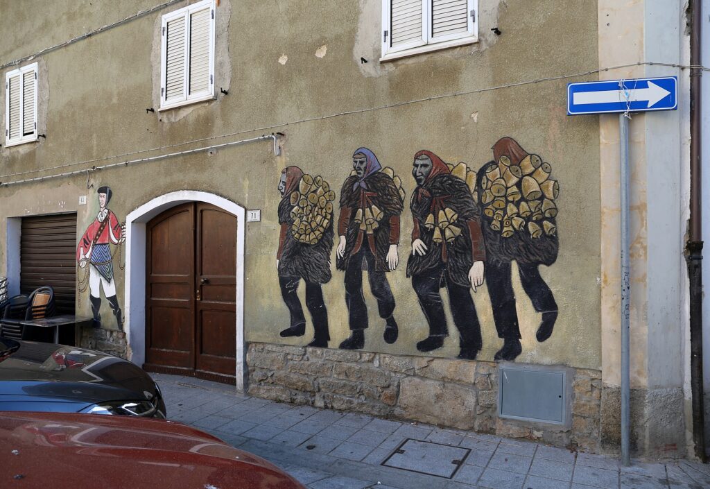 Murale con Mamuthones e Issohadore su una casa di Mamoiada