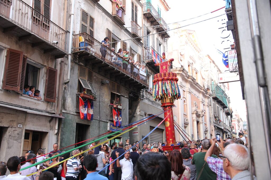 A candeliere decorated with coloured ribbons amid the crowd in the streets of Sassari during the Faradda