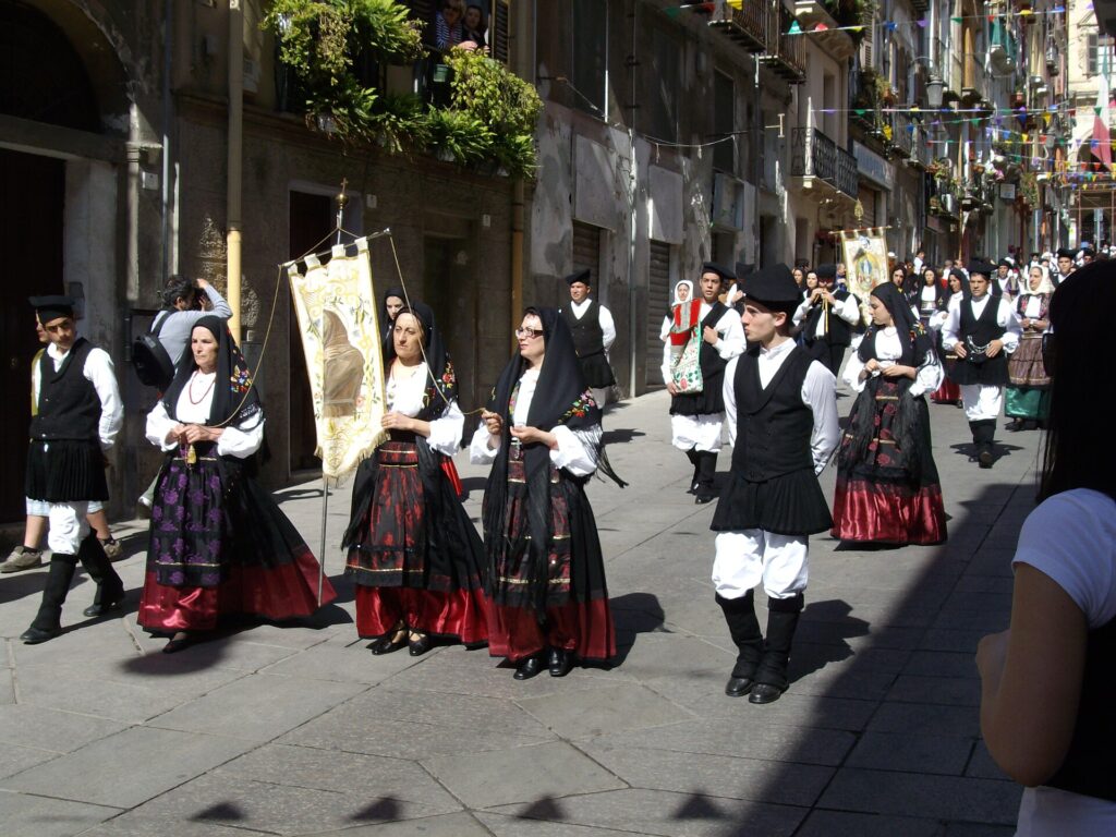 Groups in Sardinian costume with a banner in the Sant'Efisio procession in Cagliari