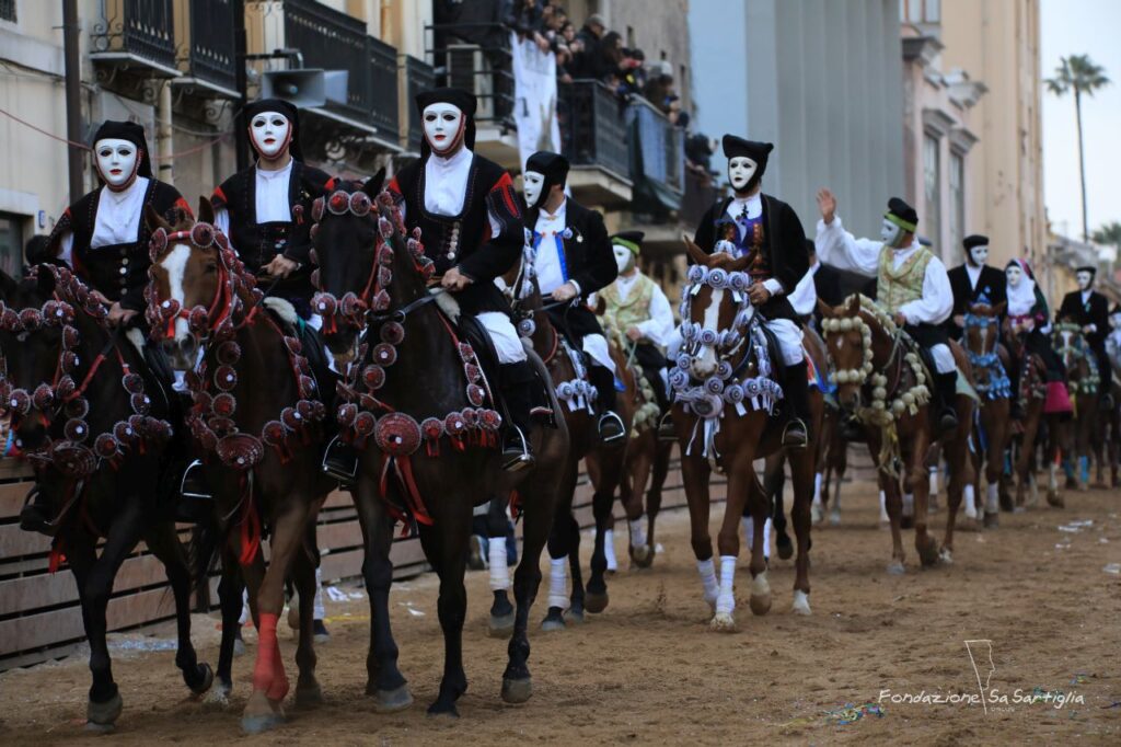 Masked riders parading on horseback along Via Mazzini during the Sartiglia